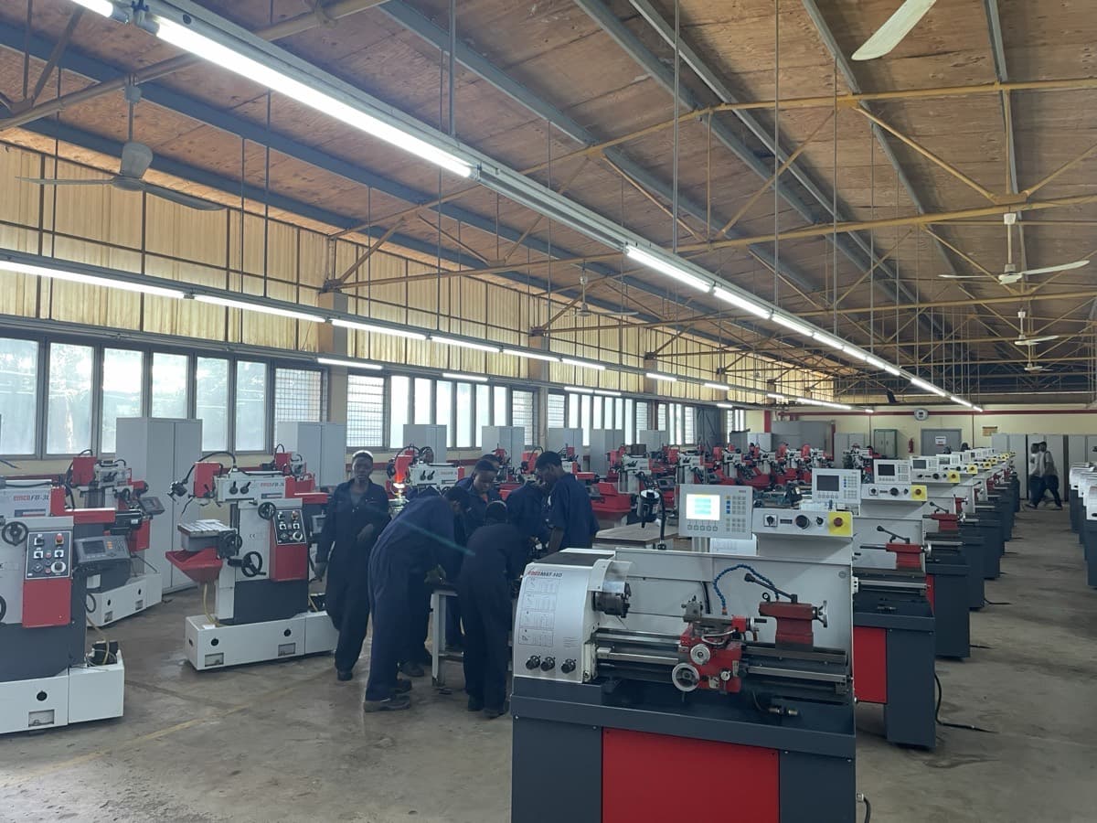 Row of lathes in an engineering workshop, operators at the machines
