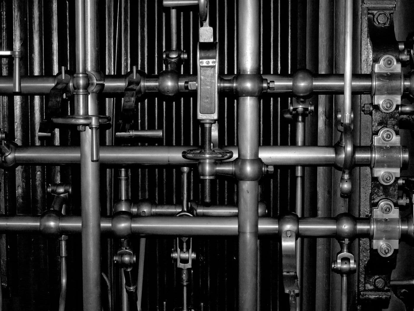Rack of pipework, handwheel valves and unions, in black and white