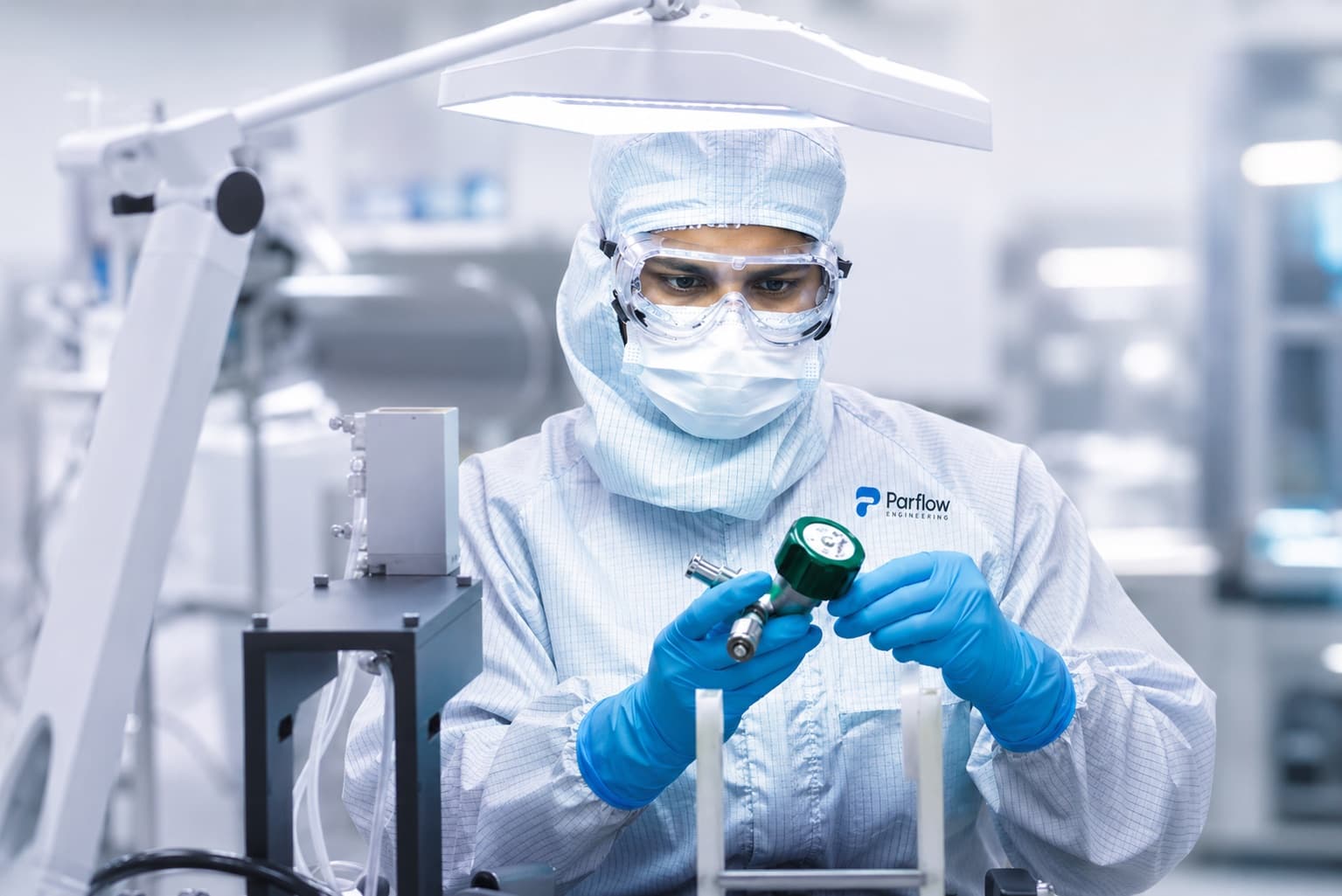 Parflow technician inspecting a valve assembly in the cleanroom